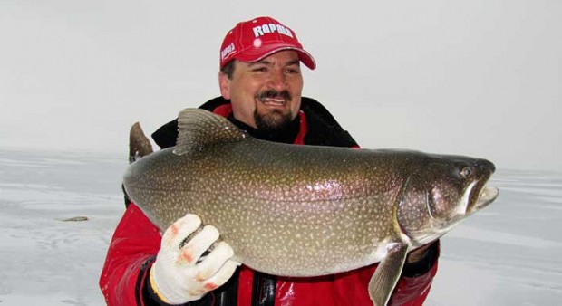 ice fishing secrets - man holding a lake trout